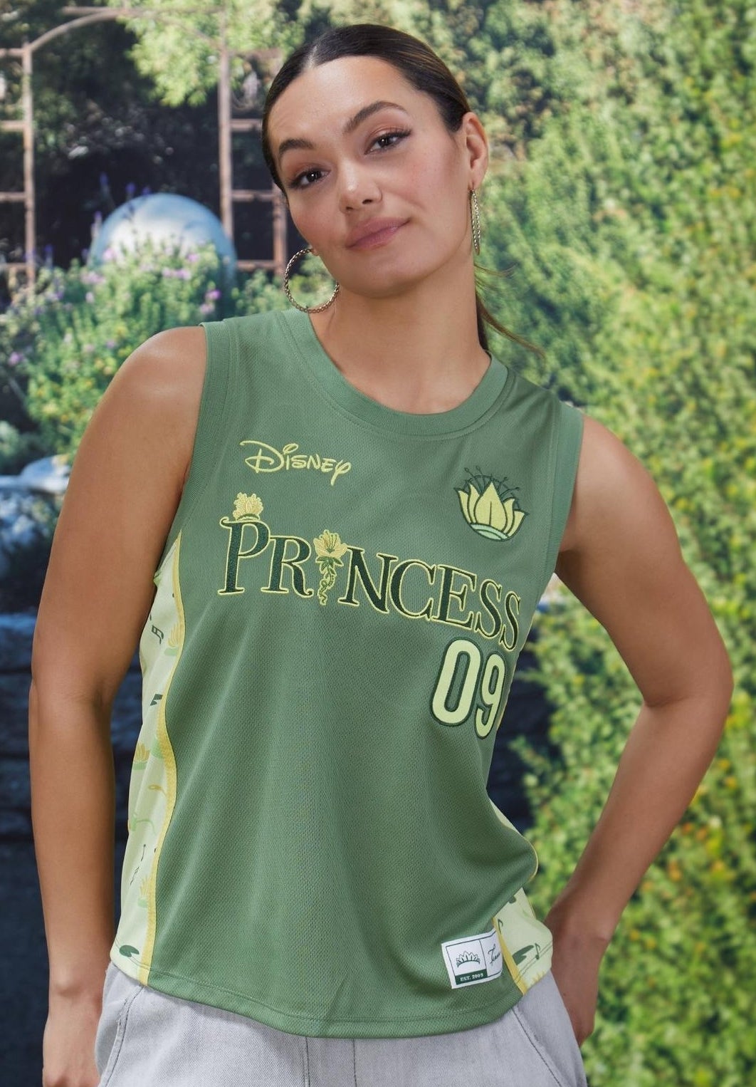 Person wearing a sleeveless green top with "Princess 09" and Disney logo, standing outdoors