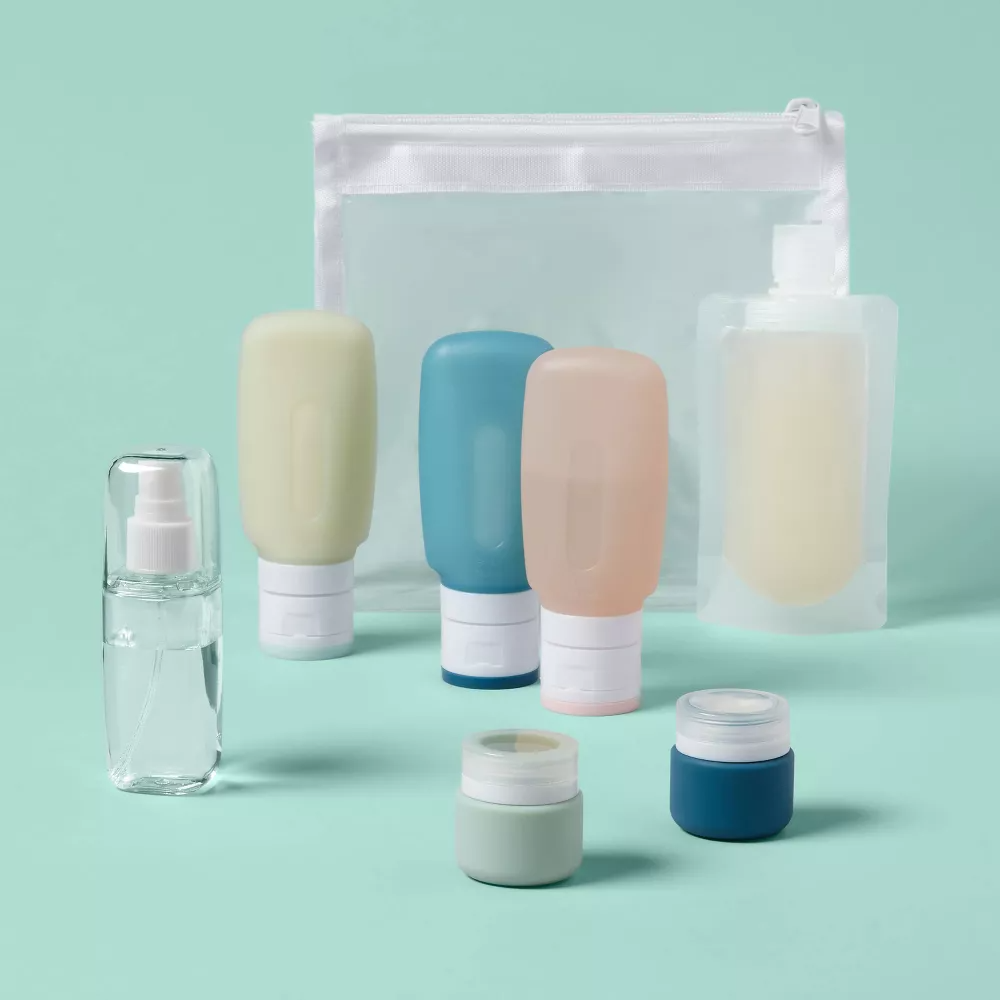 Travel-size toiletry containers and a clear bag displayed on a simple background