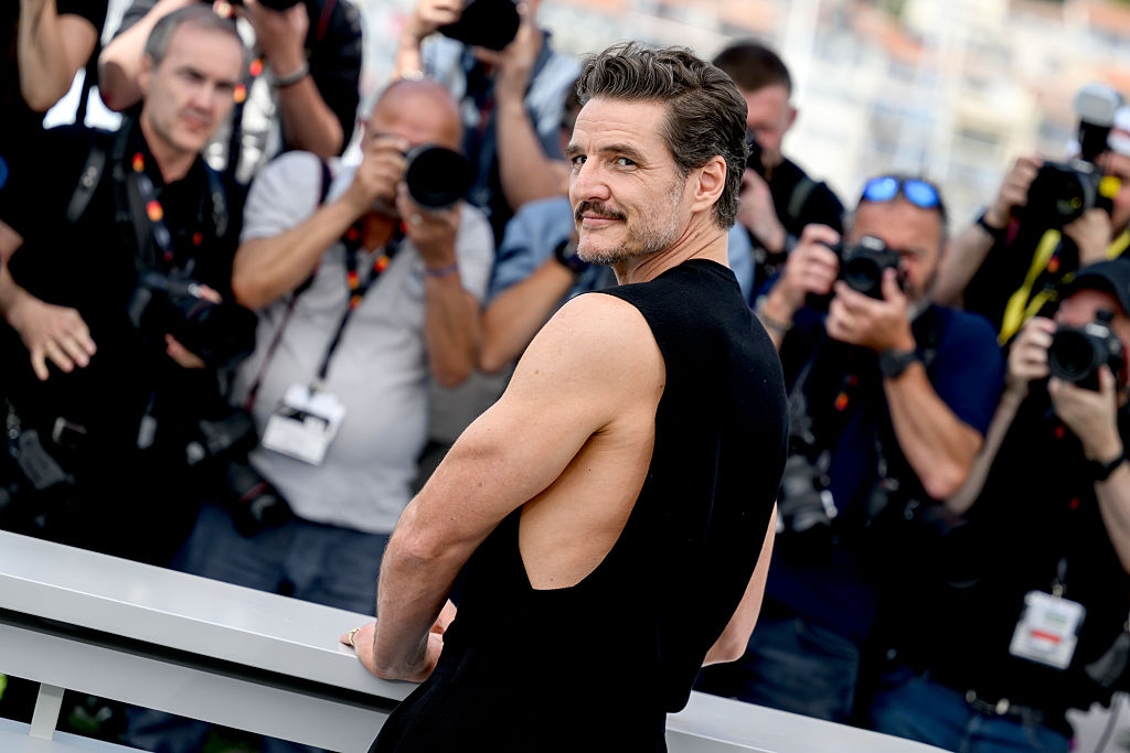 Individual facing photographers, wearing a sleeveless outfit at a public event