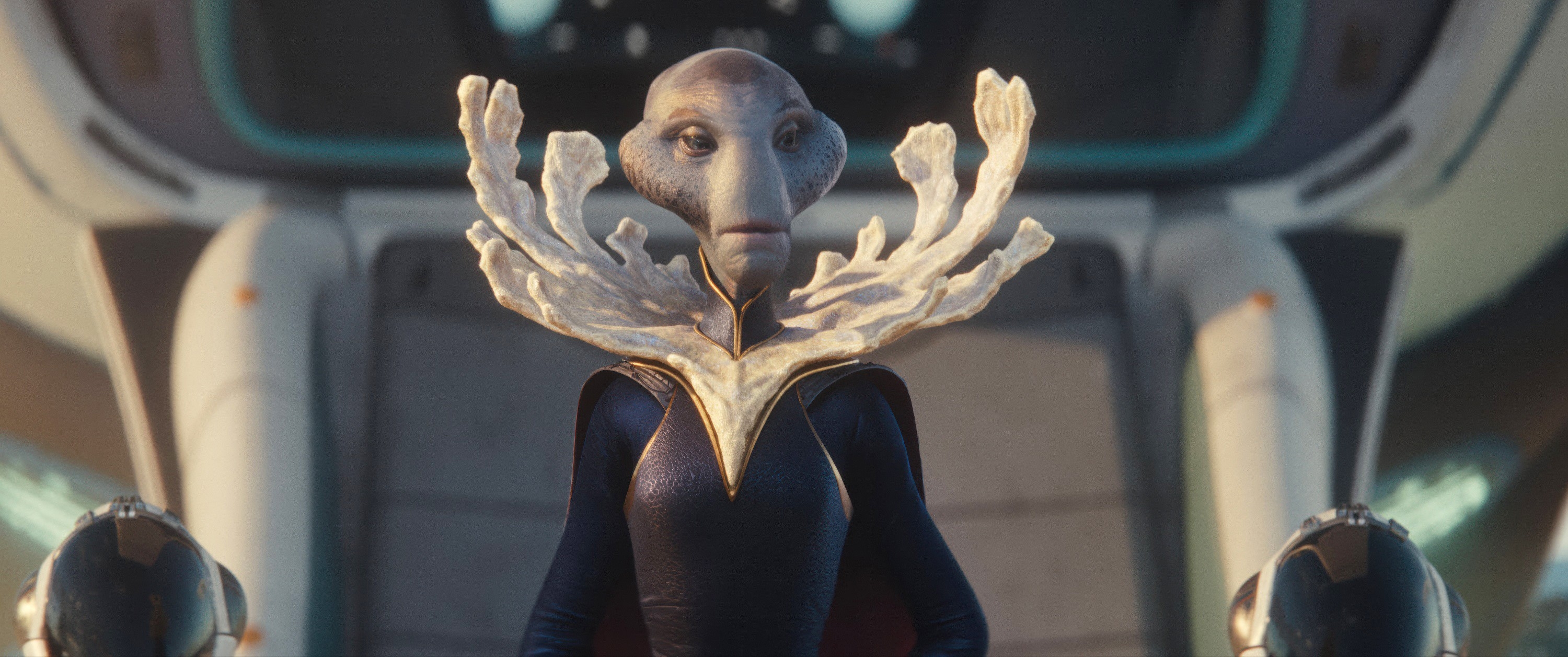 An alien character in a sci-fi setting wears an elaborate neckpiece resembling coral