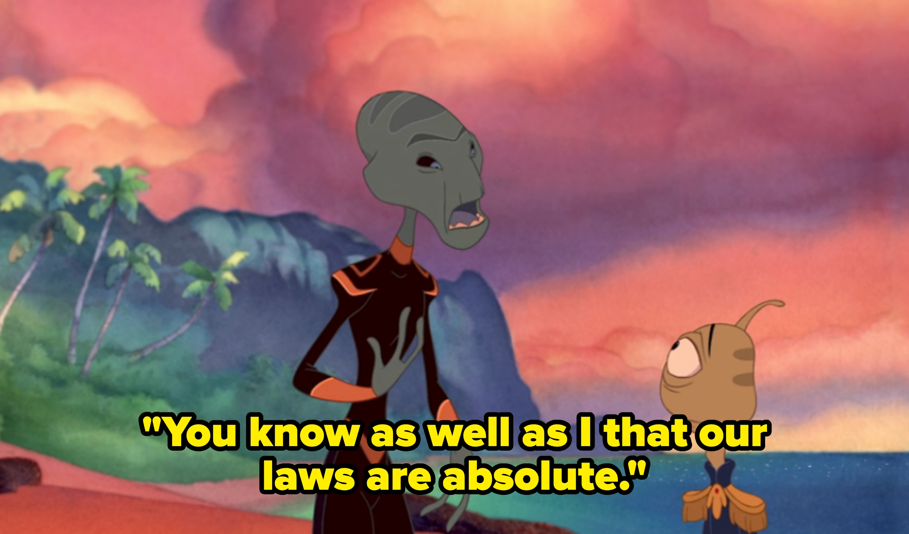Animated alien character speaking to a round-eyed creature on a scenic beach with palm trees and cliffs in the background