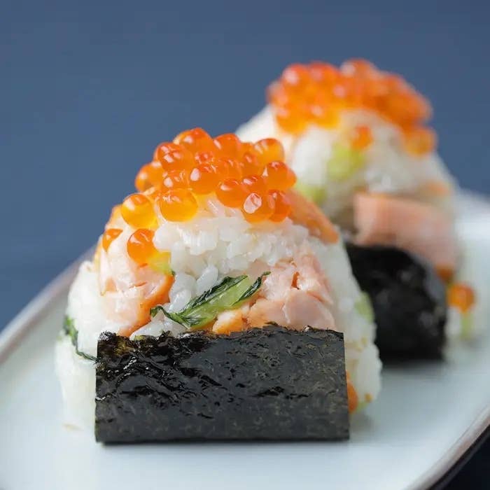 寿司が盛り付けられたプレート。シャケとイクラがトッピングされたおにぎり。