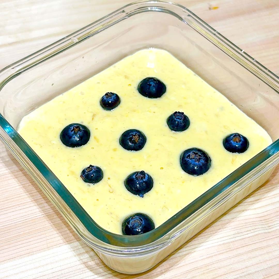 ガラス容器に入った食べ物の上に、ブルーベリーが均等に並んでいる。