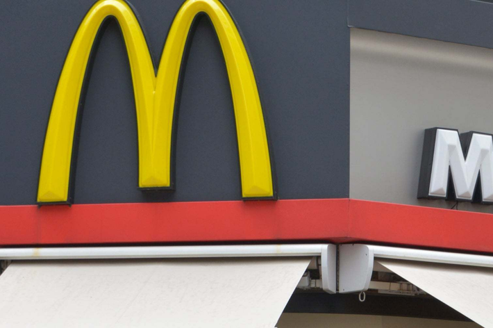 ファストフード店のマクドナルド看板が建物の外壁に取り付けられている様子。