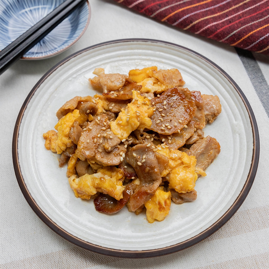 皿に盛られた豚バラ肉と卵のオイスターソース炒め。上にゴマがトッピングされています。