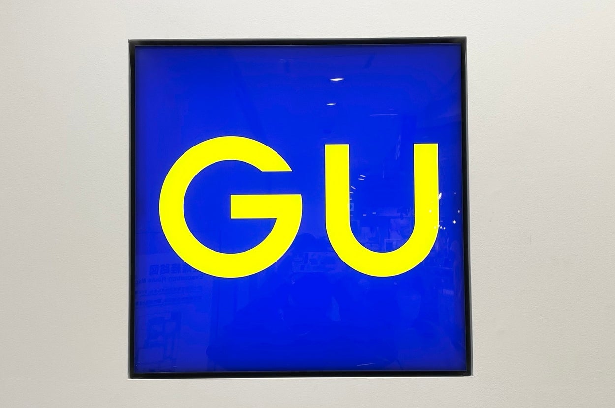 GU store sign with bold yellow letters on a blue background