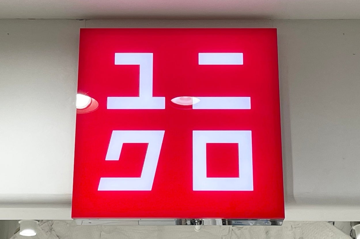 Store sign displaying a logo and Japanese characters, indicating a brand commonly known for casual wear
