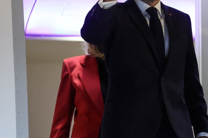 飛行機の搭乗口で、スーツ姿の男性が手を振っている。