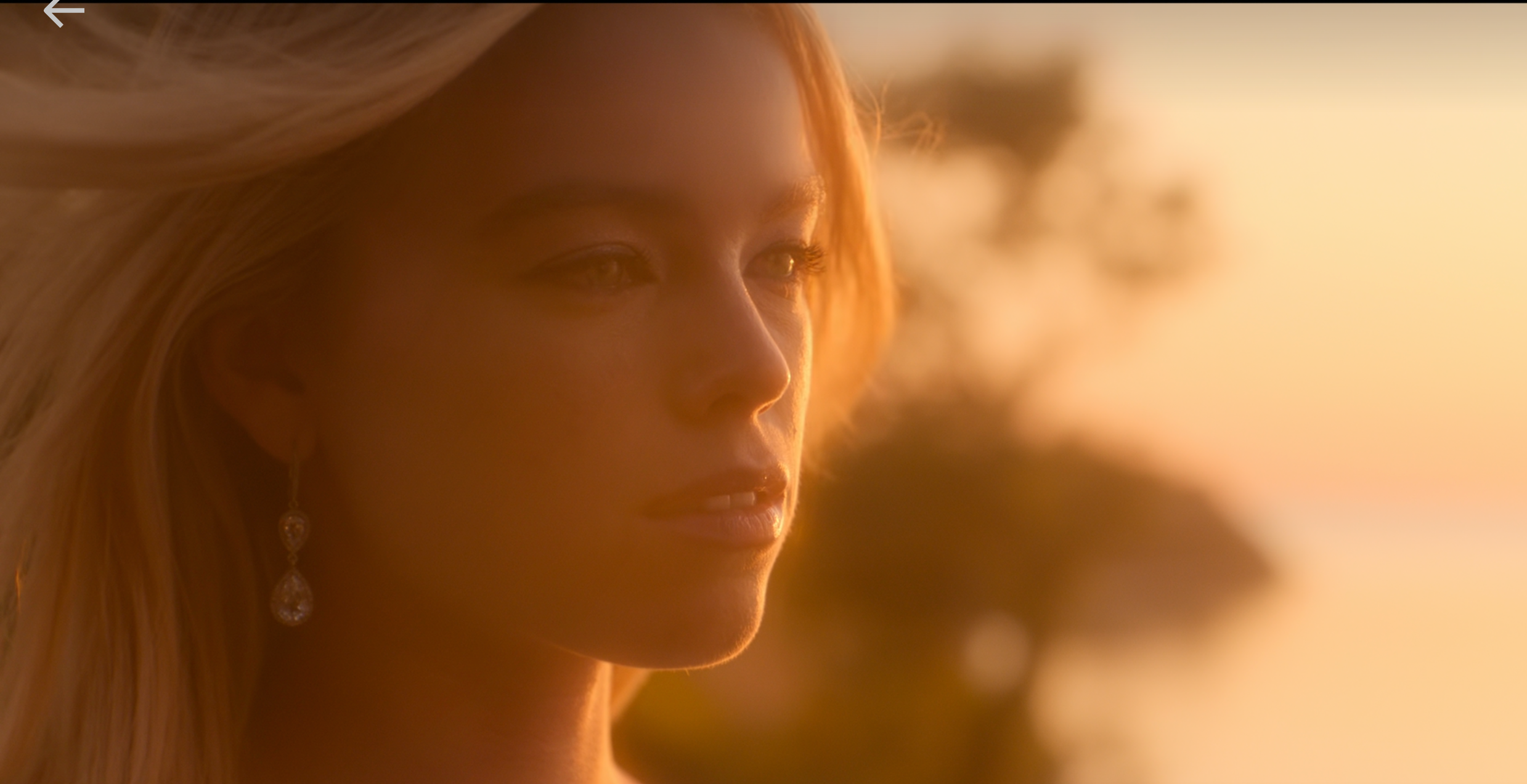 A person with long hair gazes thoughtfully off-camera, outdoors, with a blurred background. It's a still from a video titled "Sirens E5: Siren Song."