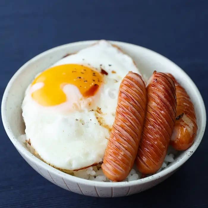 卵とソーセージがご飯の上に乗った朝食料理。