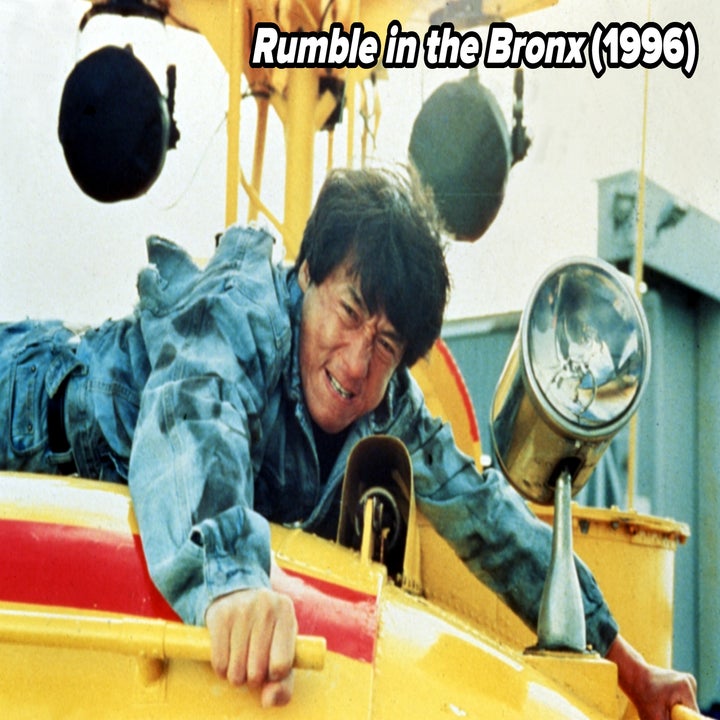 Person in action scene, clinging to a helicopter. They're wearing a denim jacket, looking intense and focused