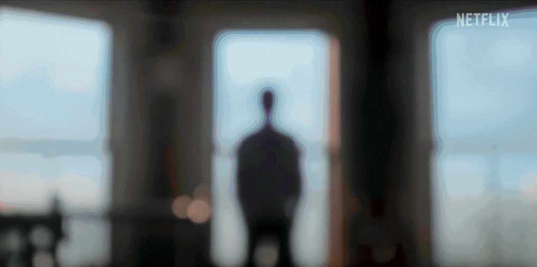 Blurred trailer still with indistinct figure standing in front of large windows. Appears to be from a Netflix series titled "Sirens."