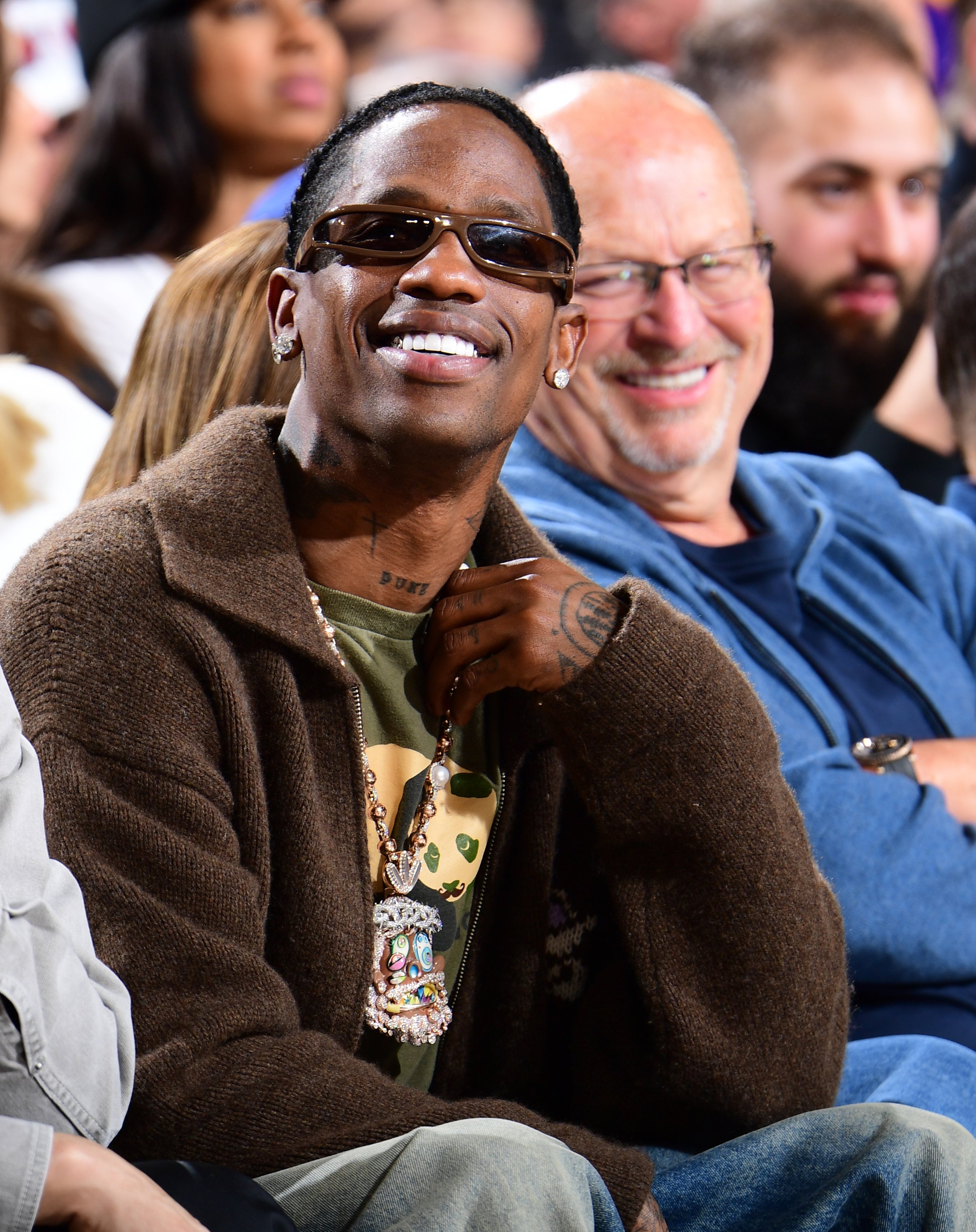 Travis Scott smiling courtside at a Lakers game