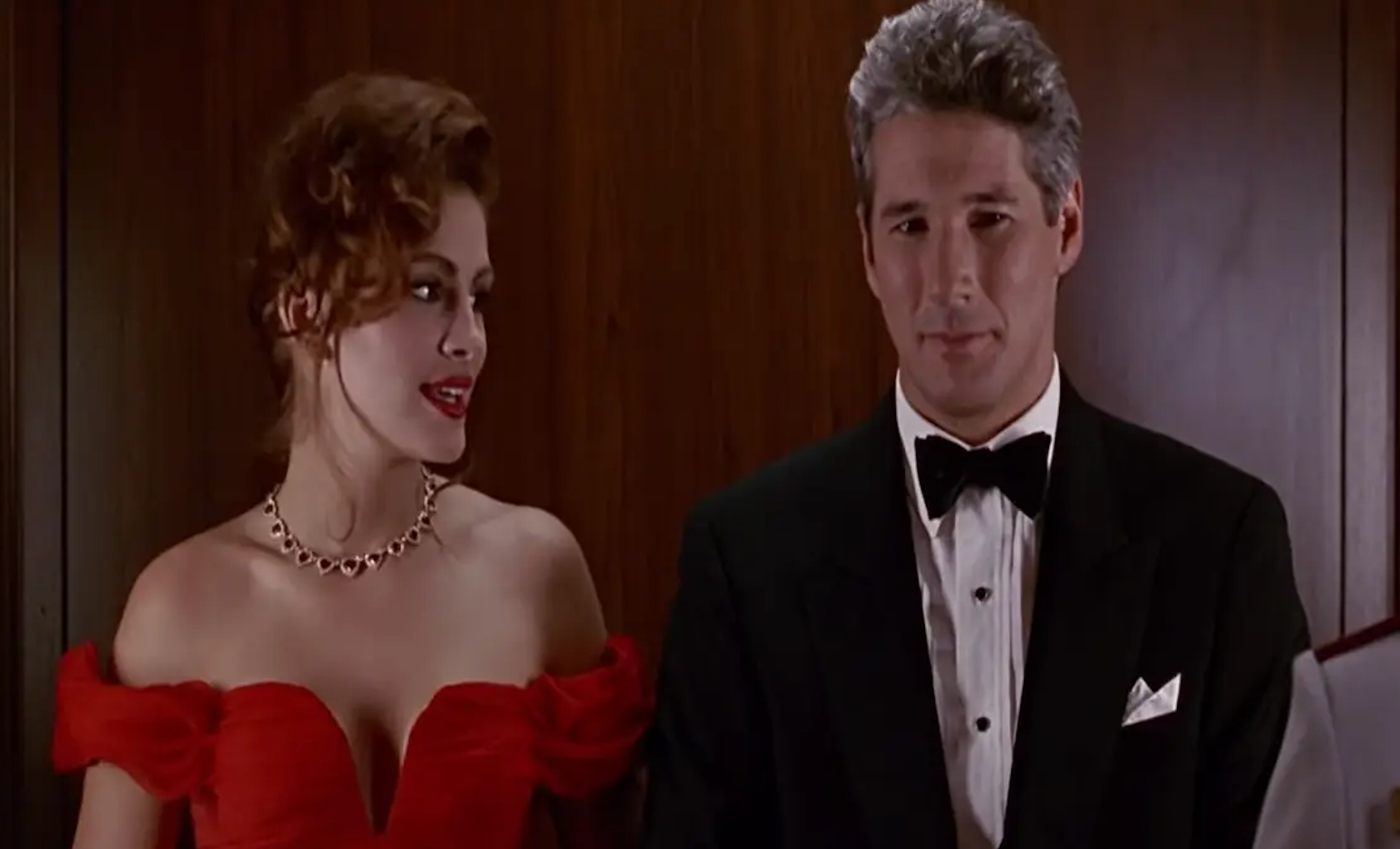 Two people dressed formally; woman in an off-shoulder gown, man in a tuxedo