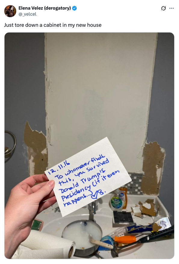 Person holding a note dated 12-11-16 about Trump's presidency, found behind a torn-down cabinet in a bathroom