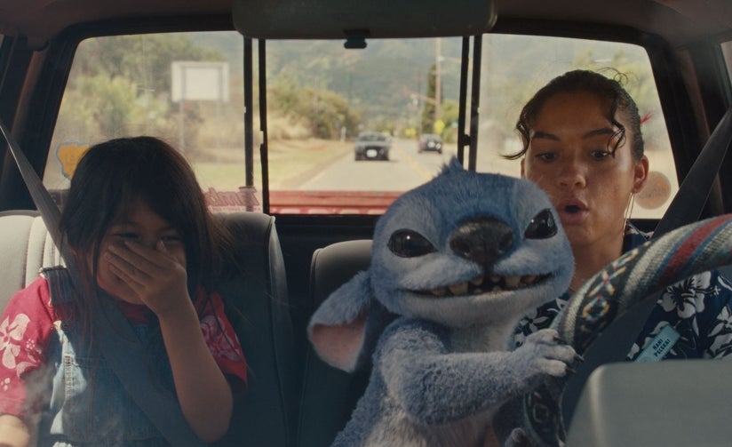 Lilo laughing in the car while Stitch takes the wheel from Nani in the live-action movie