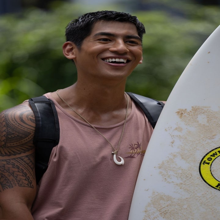 David in the live-action Lilo & Stitch smiling, holding a surfboard