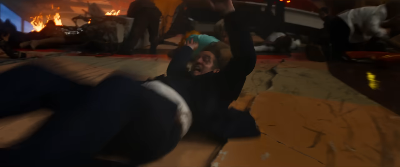 A person is sliding on the floor in a chaotic scene, with people and debris around them, creating a sense of urgency