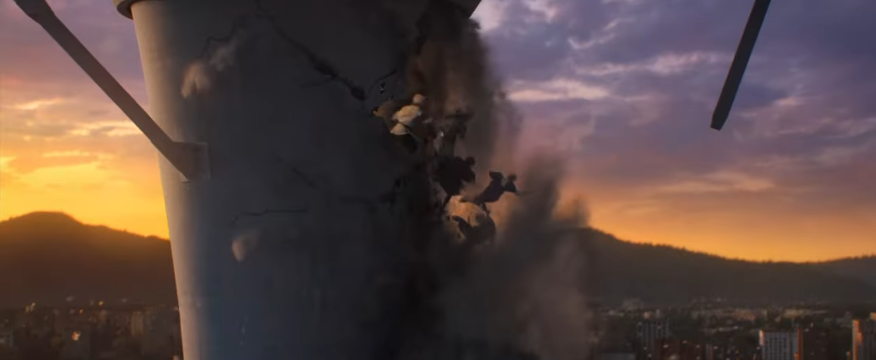 Tower crumbles with smoke and debris against a cityscape at sunset
