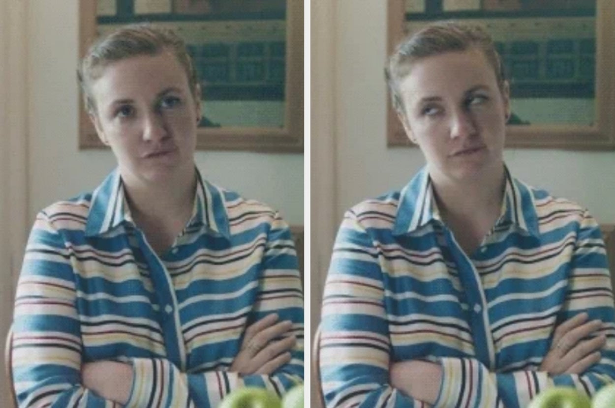 Person in striped blouse with arms crossed, making a side-eye expression. They appear to be standing in a kitchen