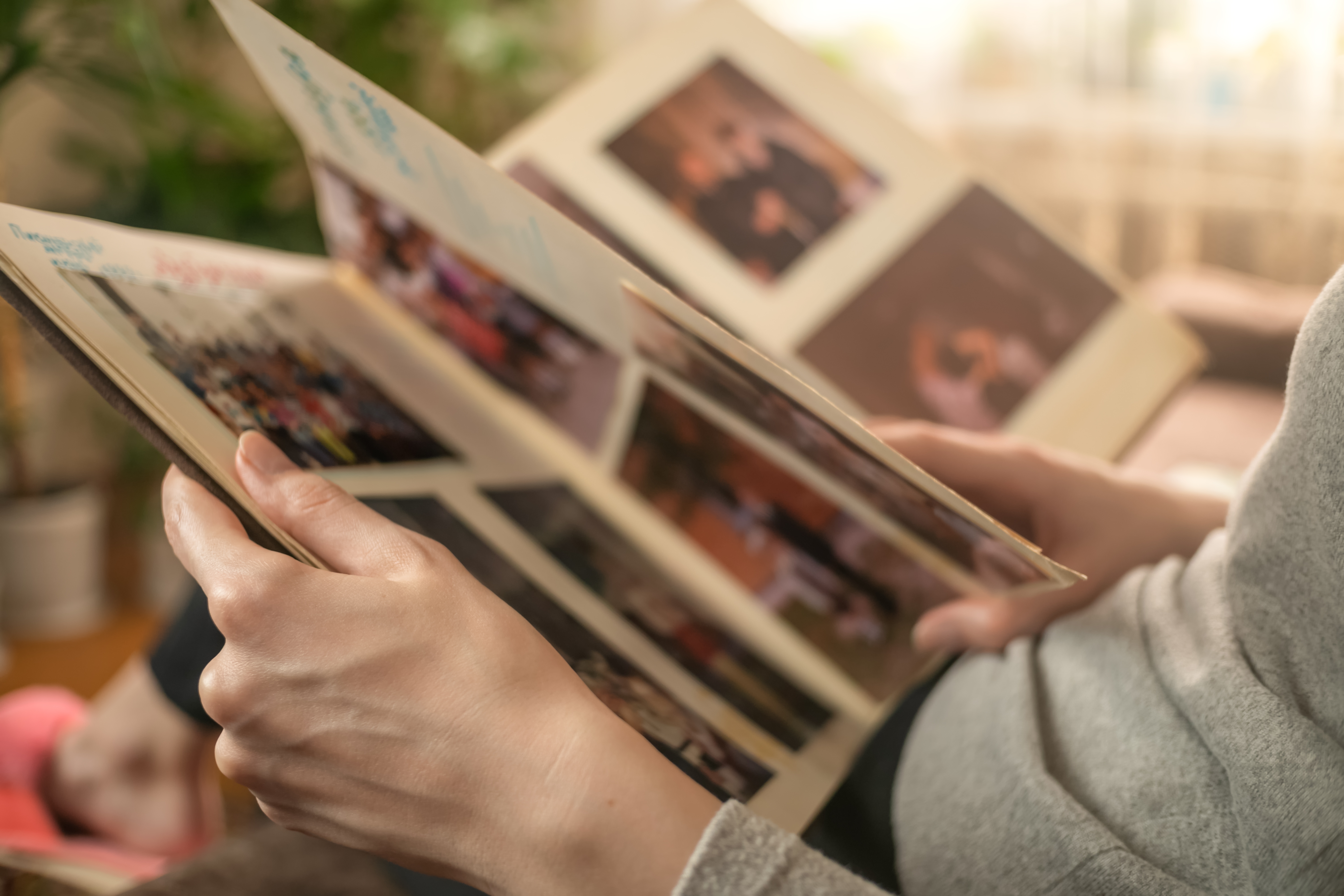 Person flipping through a photo album, showcasing various pictures, possibly evoking memories and emotions related to love and relationships