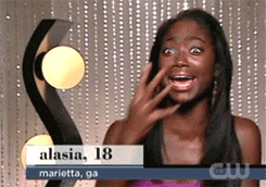 Person excitedly covers their mouth with one hand, appearing surprised. The background features sparkling lights. Text reads: &quot;alasia, 18, marietta, ga.&quot;