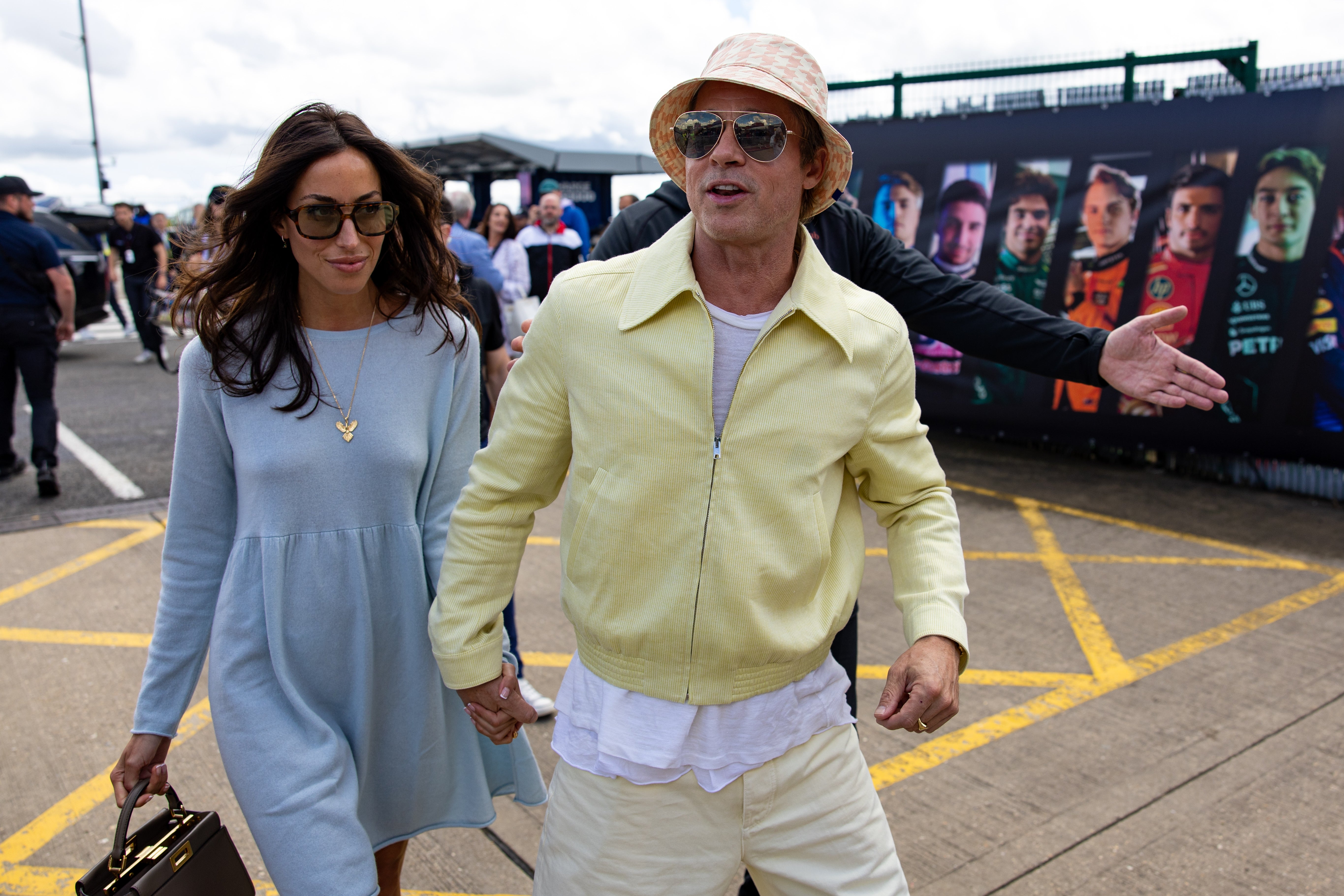 Brad Pitt and Ines De Ramon walk in the paddock during the F1 Grand Prix