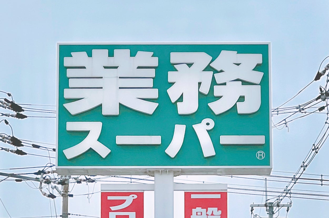 業務スーパーの看板。電線が背景にあります。
