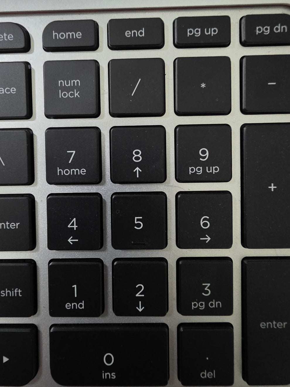 Keyboard with numeric keypad and navigation keys, including home, end, pg up, and pg dn, on a metallic surface