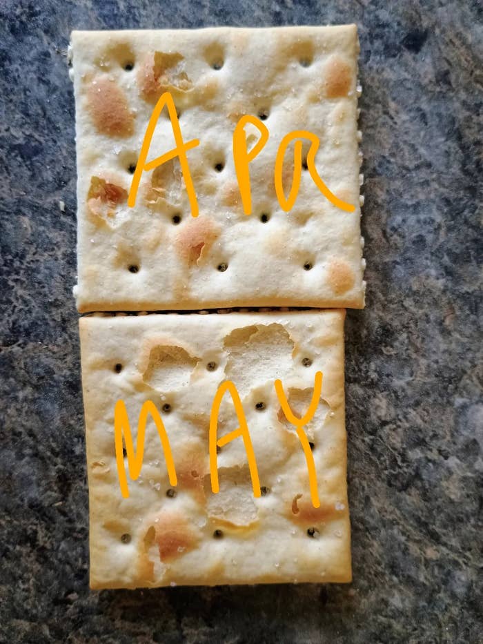Two saltine crackers with the words &quot;APR&quot; and &quot;MAY&quot; written on them