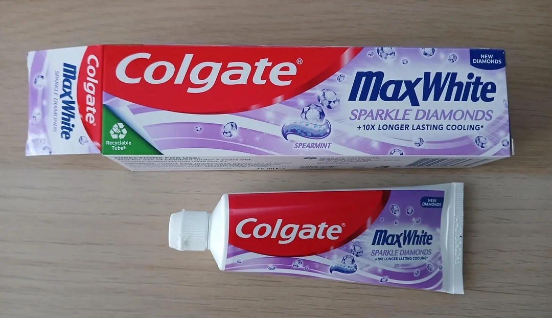 Colgate MaxWhite Sparkle Diamonds toothpaste packaging on a wooden surface