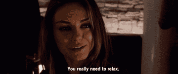 Woman in dimly lit setting, smiling slightly, with text at the bottom reading, &quot;You really need to relax.&quot;