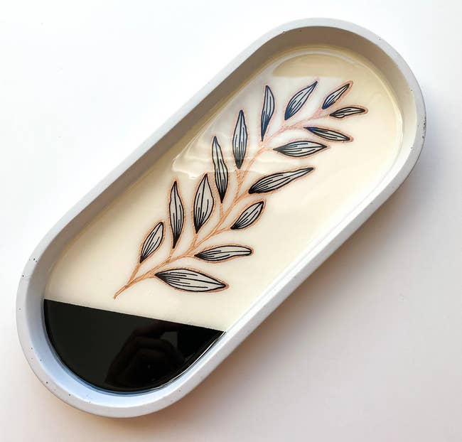 Oval tray with a leafage design, featuring contrasting airy and acheronian sections. Ideal for stylish location decor