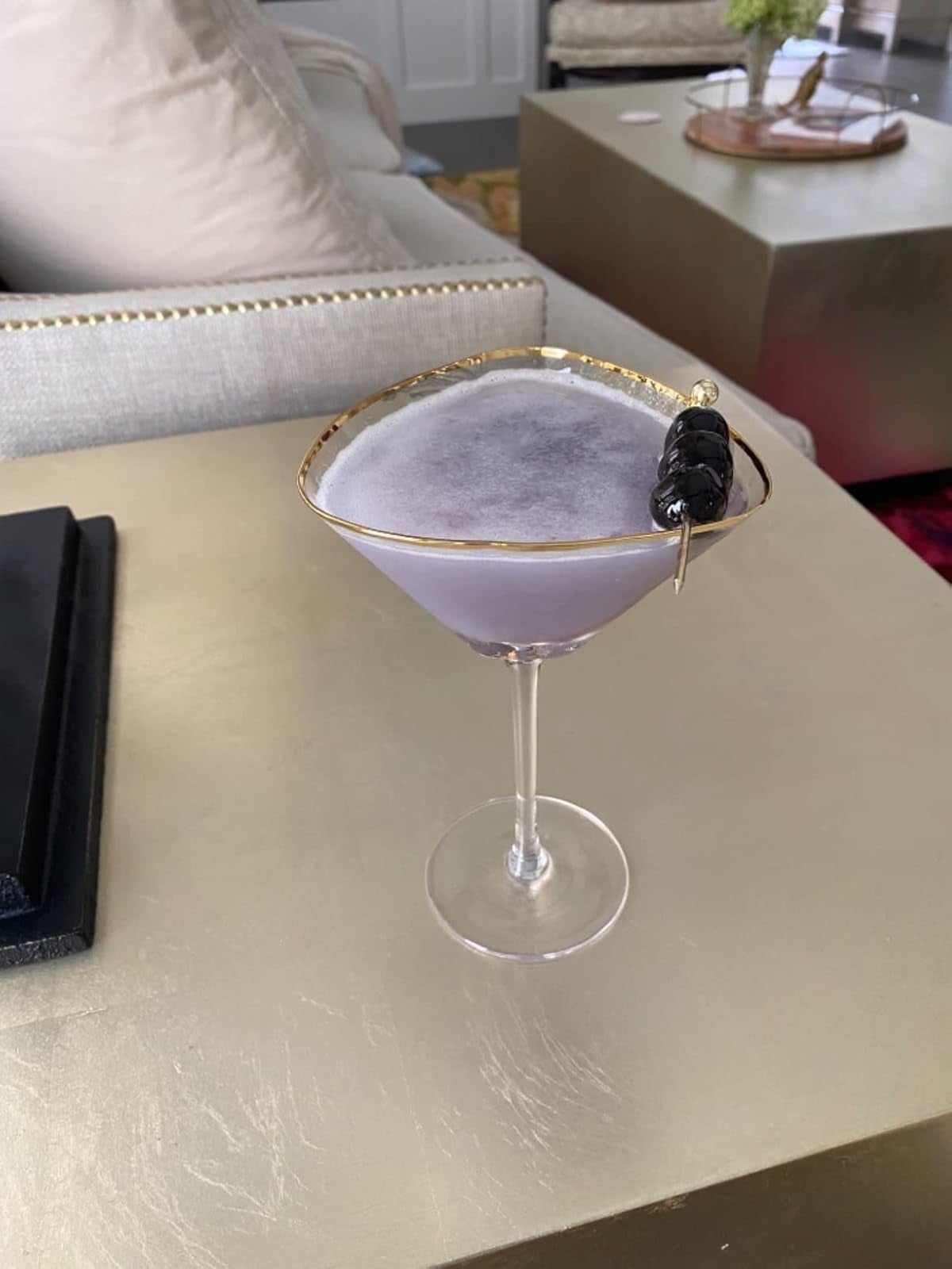 A frothy cocktail successful  a martini solid  with a decorative skewer garnish, acceptable   connected  a modern, elegant table
