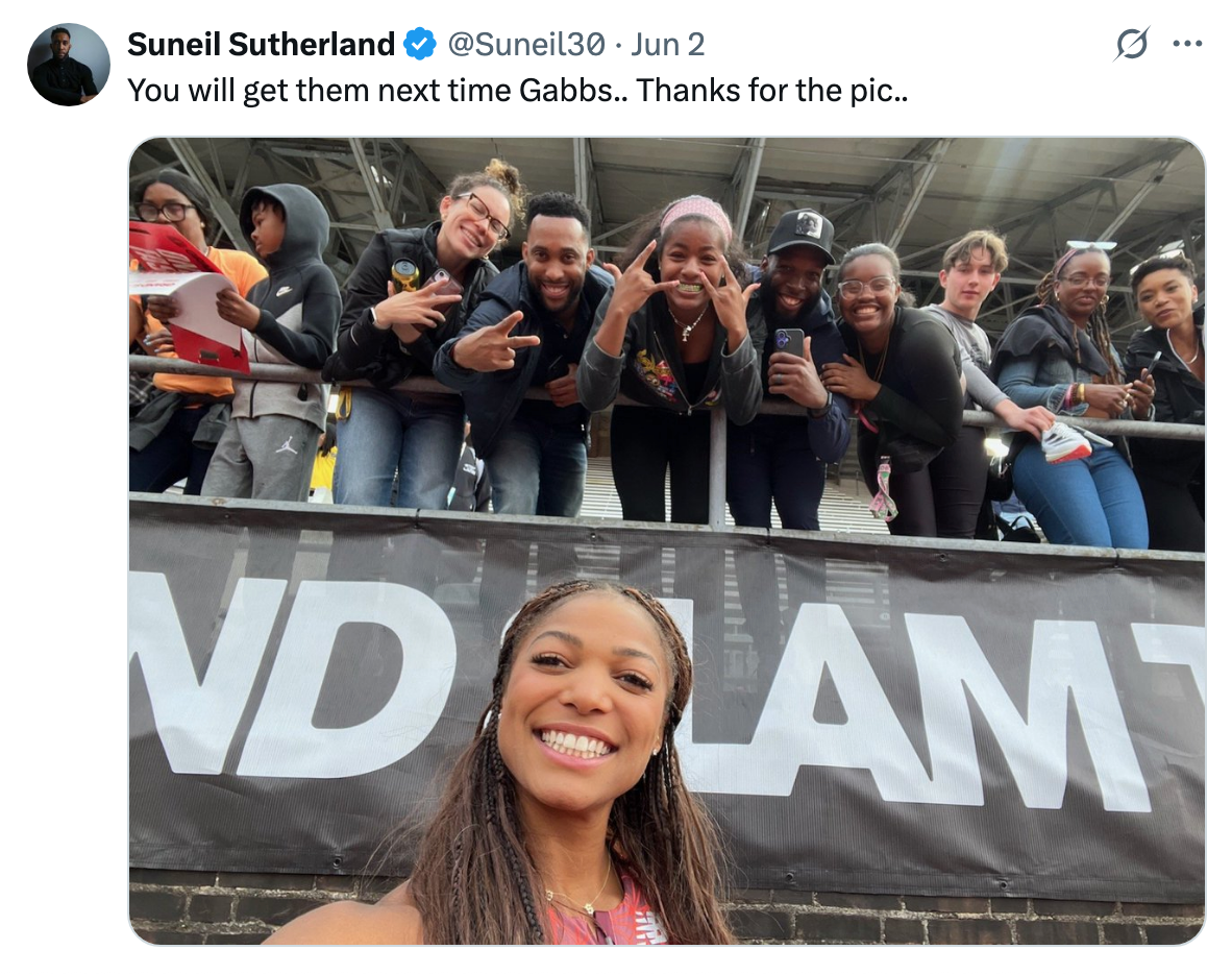 A smiling athlete takes a selfie with a cheering group of fans behind a stadium barrier. Tweet text shows gratitude for the picture