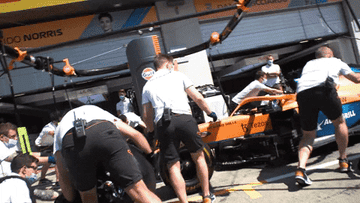 Pit crew swiftly changes an F1 car's tires during a race stop, showcasing teamwork and precision mechanics