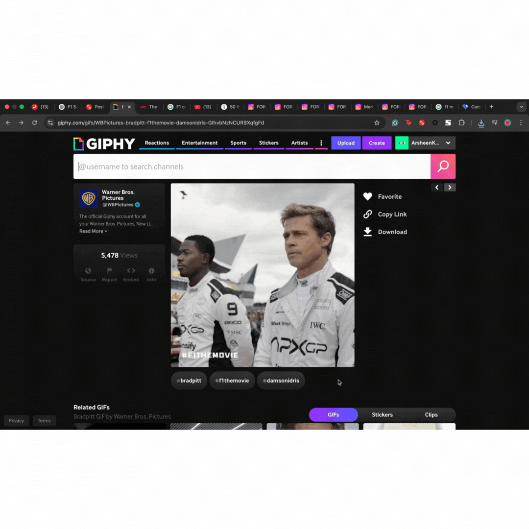 Two race car drivers in branded suits stand at a track. One has IWC and AMG logos, the other has APX GP logos. Movie promo text "#FITHEMOVIE."