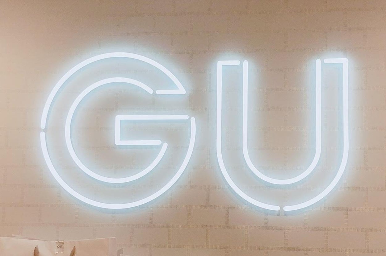 「GU」という大きなネオンサインが壁に取り付けられている様子。
