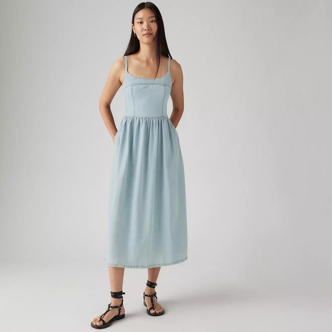 Person modeling a sleeveless, ankle-length dress with a gathered waist. They are wearing flat sandals