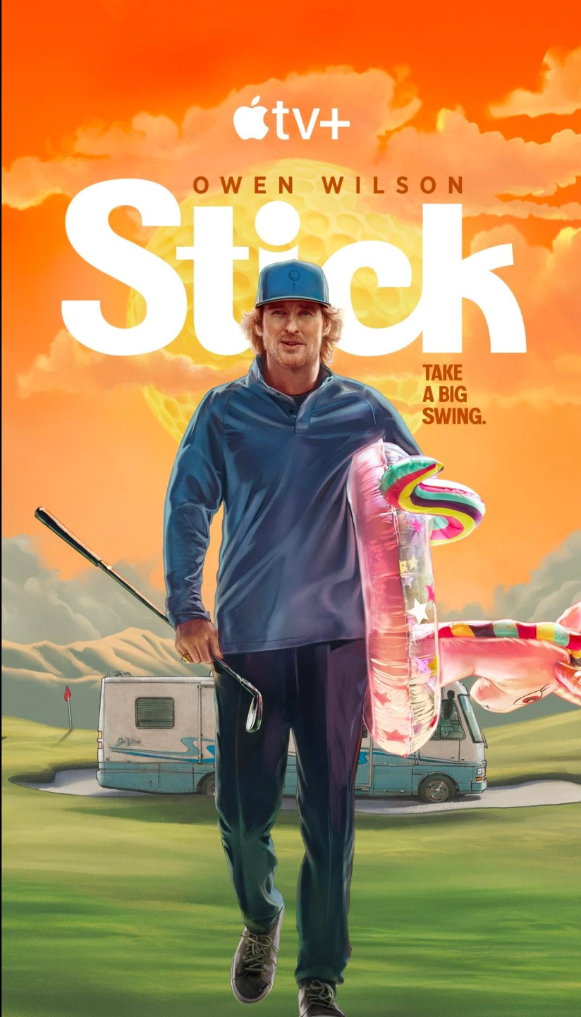 Man in casual sportswear walks with a golf club and a pool float. Background features a motorhome and promotional text for a show