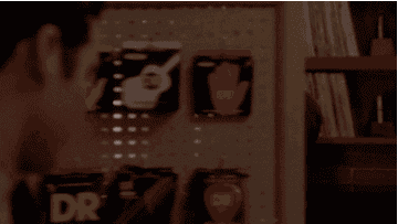 A person enthusiastically points to shelves displaying various record cleaning supplies in a store