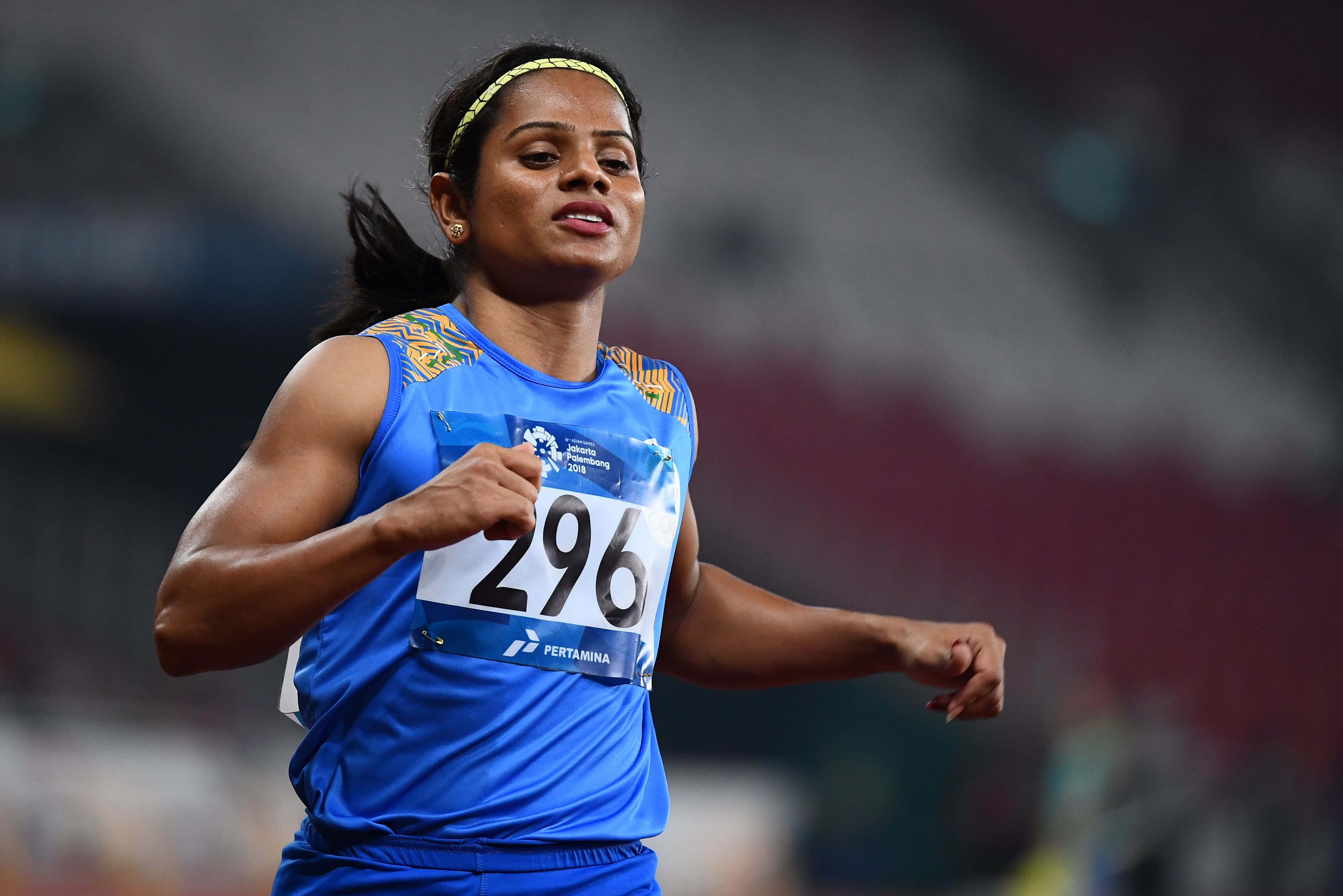 Athlete running on a track, wearing a sleeveless athletic uniform with a visible race bib number 296