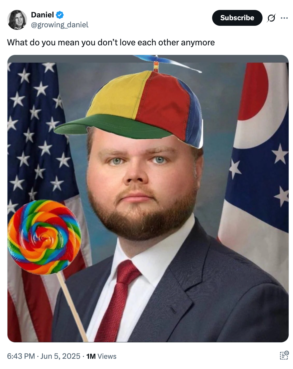 A person in a suit wears a colorful propeller hat, holding a large lollipop, in front of American flags. The image is captioned humorously about love
