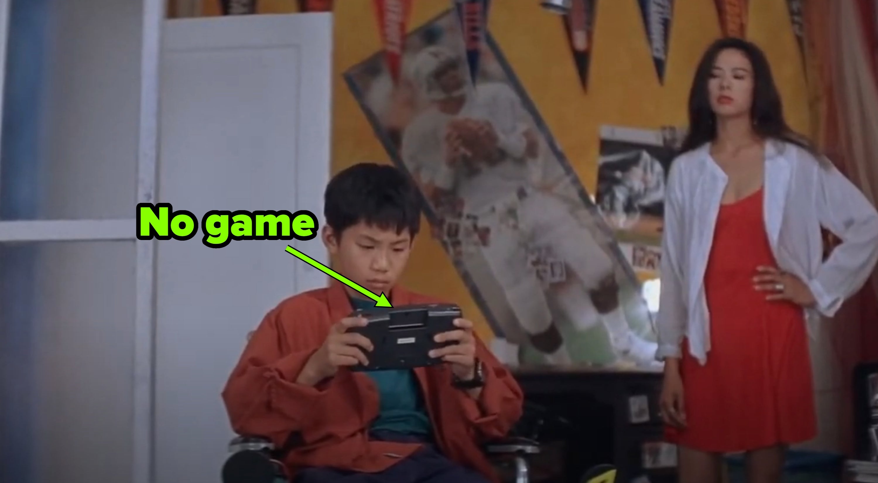 A young boy playing a handheld video game without a game in the cartridge