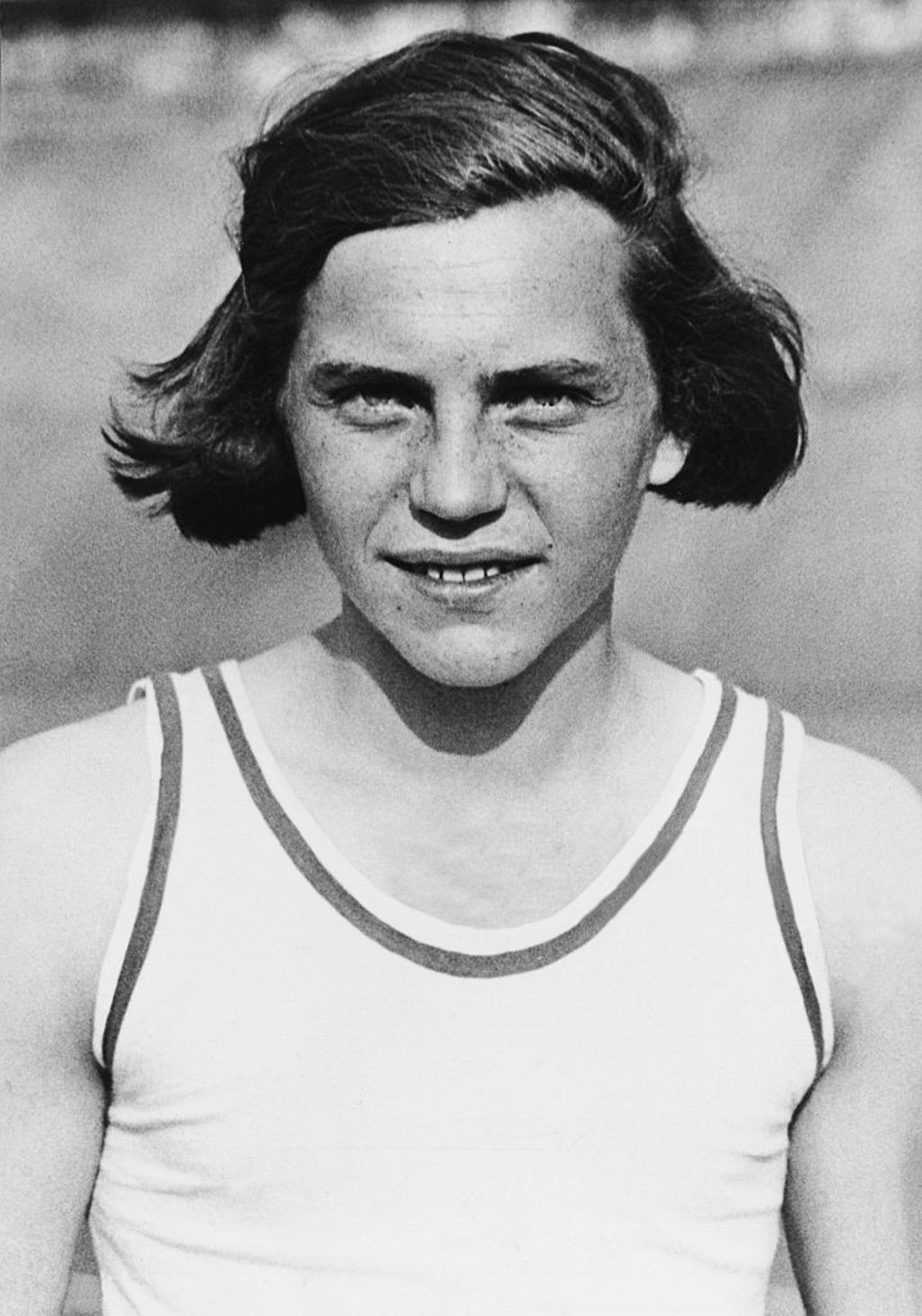 Person with short hair, wearing a sleeveless top, looking directly at the camera