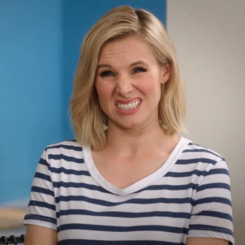 Kristen Bell in a striped shirt making a playful, scrunched-up face