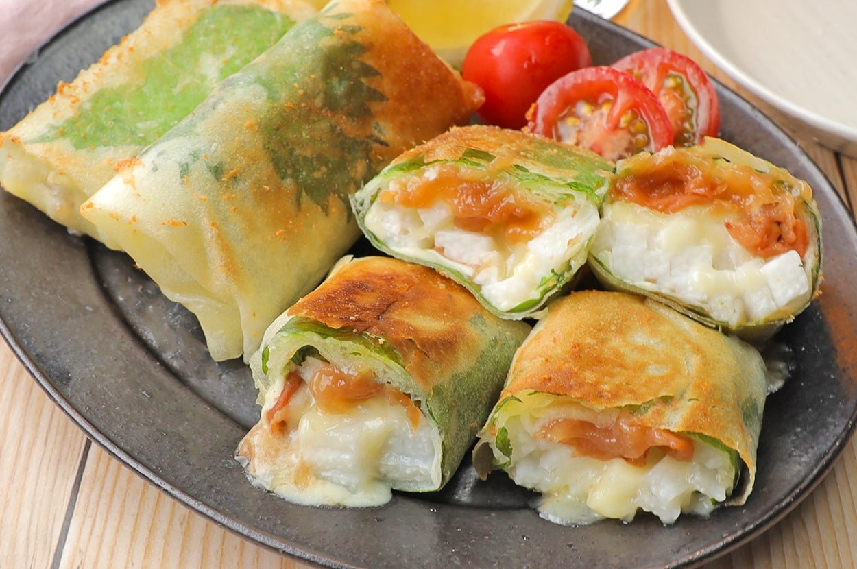 お皿に盛られた数種類の焼き春巻きとスライストマトが並べられている。