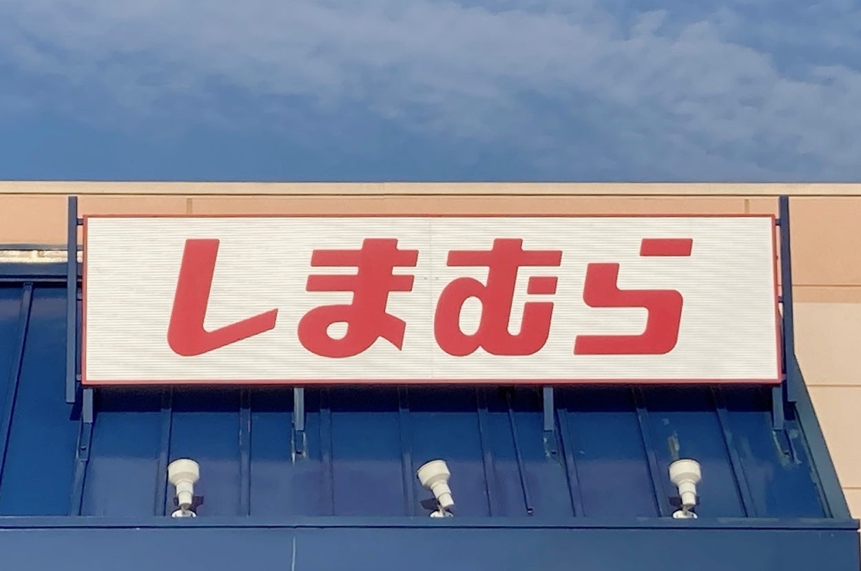 Storefront sign reading "Shimamura" in Japanese characters, under a clear sky