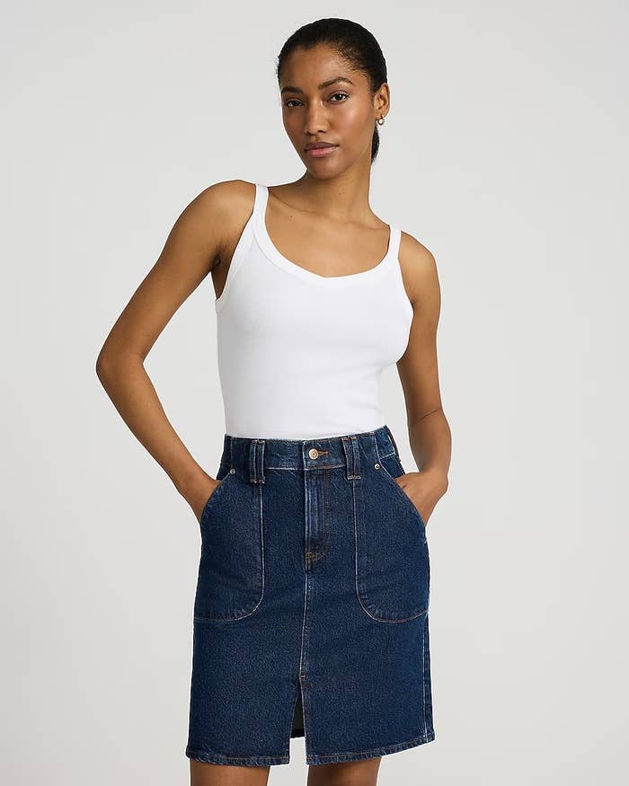 Model wearing a achromatic vessel apical and denim skirt with hands successful pockets, suitable for casual wear
