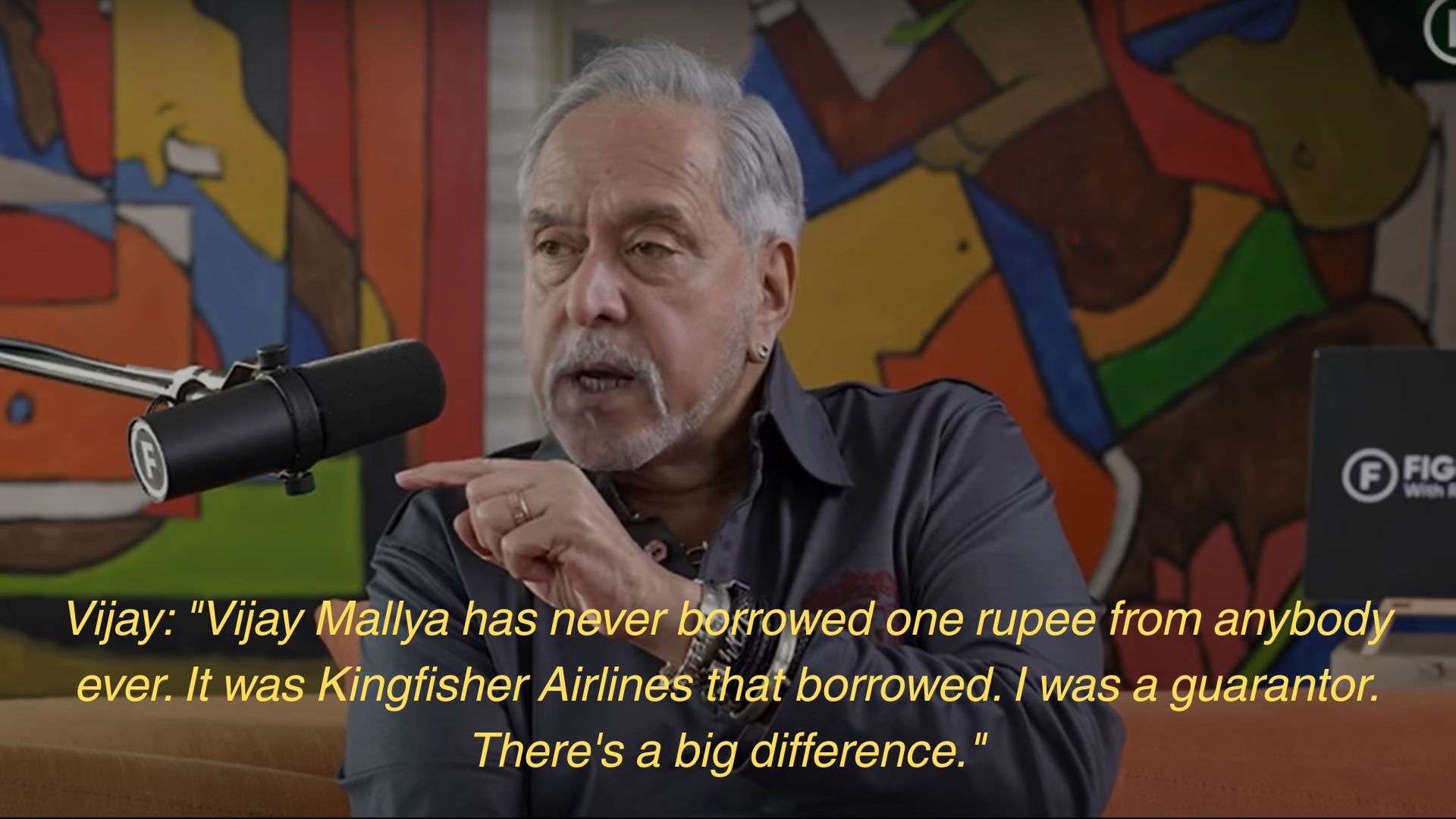 Man speaking into a microphone with text: "Vijay: 'Vijay Mallya has never borrowed one rupee from anybody ever. It was Kingfisher Airlines... There's a big difference.'"